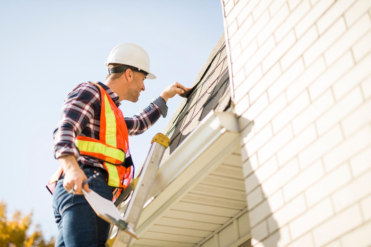 a,man,with,hard,hat,standing,on,steps,inspecting,house